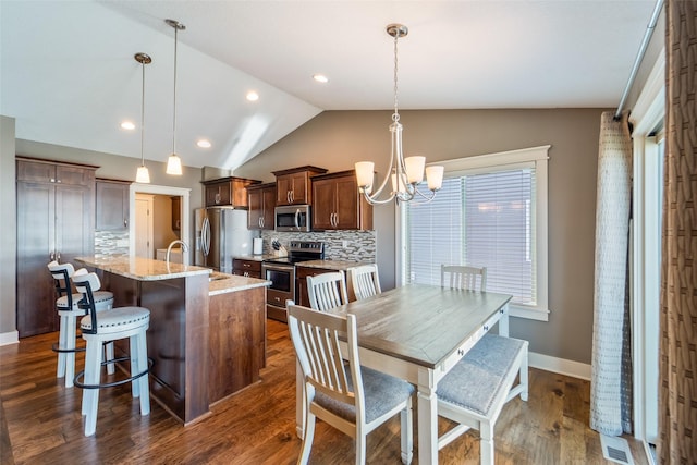 716 James St NE, Bondurant, IA 50035 - dining room featuring vaulted ceiling, a chandelier, and dark wood-type flooring