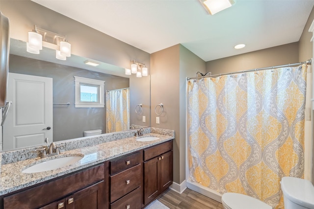 716 James St NE, Bondurant, IA 50035 - bathroom with double vanity, wood finished floors, and a shower with curtain