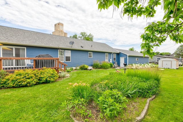 201 E 1st St, Woodward, IA 50276 - back of house with a wooden deck, a lawn, a chimney, and a shed