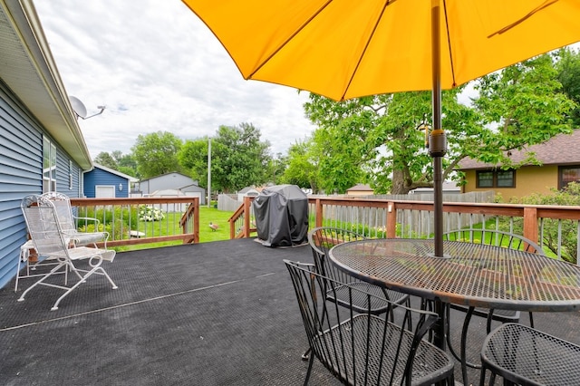 201 E 1st St, Woodward, IA 50276 - wooden deck featuring outdoor dining area, grilling area, and an outdoor structure