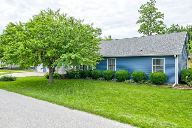 201 E 1st St, Woodward, IA 50276 - view of front of house featuring a shingled roof, a front lawn, and a chimney