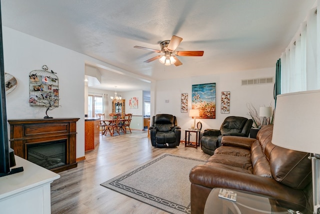 201 E 1st St, Woodward, IA 50276 - living room with a ceiling fan, light wood finished floors, and a chandelier