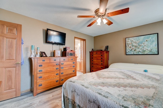 201 E 1st St, Woodward, IA 50276 - bedroom with light wood-style floors, ceiling fan, and connected bathroom