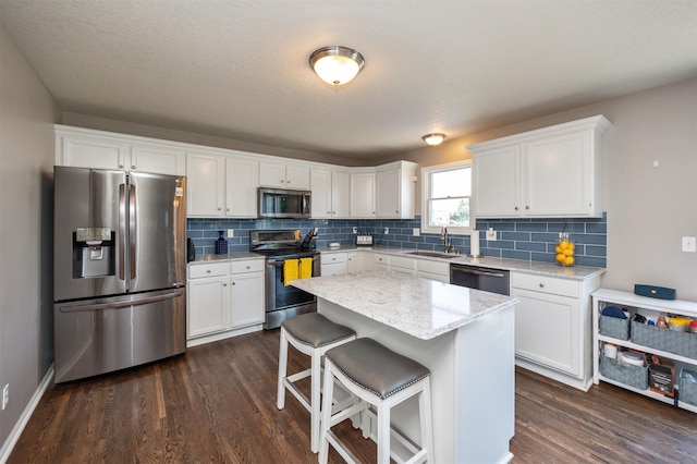4104 SW 2nd St, Ankeny, IA 50023 - kitchen with stainless steel appliances, dark wood-type flooring, white cabinetry, and tasteful backsplash