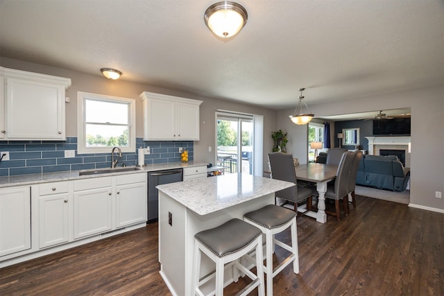 4104 SW 2nd St, Ankeny, IA 50023 - kitchen featuring stainless steel dishwasher, dark wood-type flooring, tasteful backsplash, white cabinetry, and a breakfast bar area