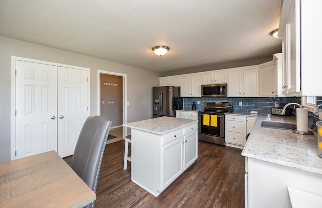 4104 SW 2nd St, Ankeny, IA 50023 - kitchen with appliances with stainless steel finishes, white cabinets, backsplash, and dark wood finished floors