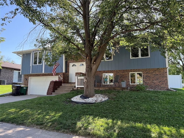 410 N 6th St, Winterset, IA 50273 - view of front facade with brick siding, a front lawn, a garage, and concrete driveway