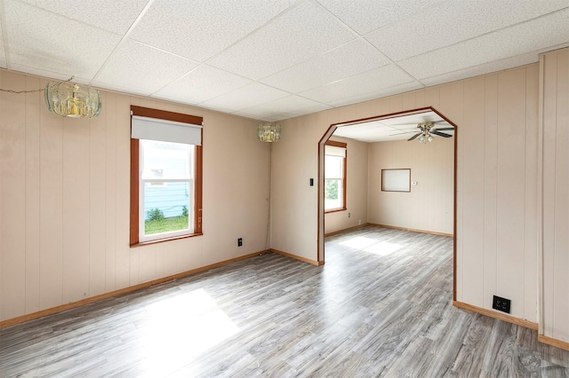 1442 Lucas Ave, Chariton, IA 50049 - empty room with wood finished floors, a paneled ceiling, arched walkways, and ceiling fan