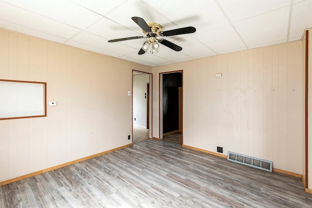 1442 Lucas Ave, Chariton, IA 50049 - unfurnished room featuring wood finished floors, ceiling fan, and wood walls