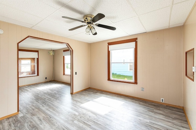 1442 Lucas Ave, Chariton, IA 50049 - empty room with light wood-style floors, a ceiling fan, arched walkways, and wood walls