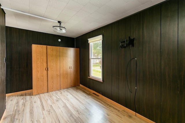 1442 Lucas Ave, Chariton, IA 50049 - unfurnished bedroom with wood finished floors and wooden walls