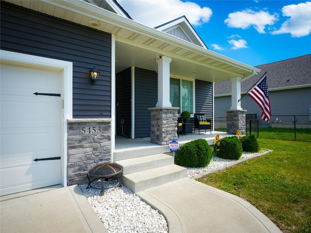 5453 Rowling Dr, Ames, IA 50014 - view of exterior entry featuring covered porch, a garage, and stone siding