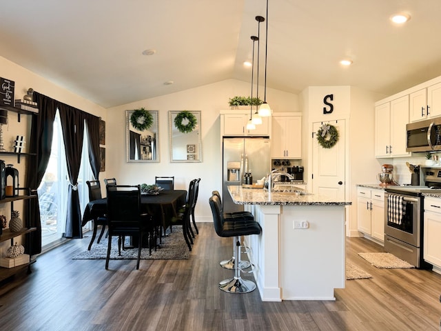 5453 Rowling Dr, Ames, IA 50014 - kitchen with appliances with stainless steel finishes, light stone counters, vaulted ceiling, decorative backsplash, and dark wood-style floors