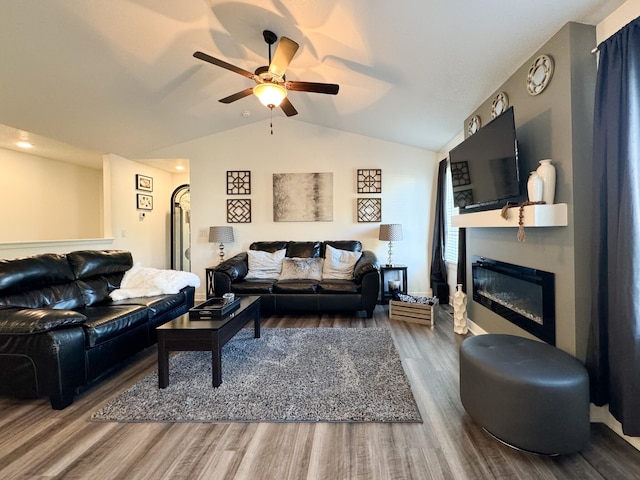 5453 Rowling Dr, Ames, IA 50014 - living room featuring lofted ceiling, ceiling fan, wood finished floors, and a glass covered fireplace