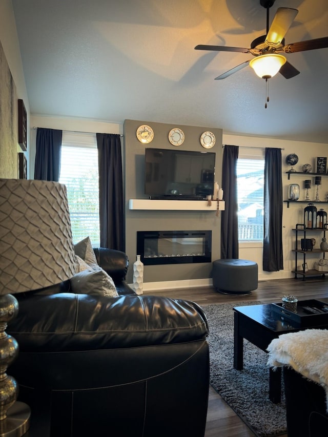 5453 Rowling Dr, Ames, IA 50014 - living room featuring a glass covered fireplace, plenty of natural light, dark wood-type flooring, and ceiling fan