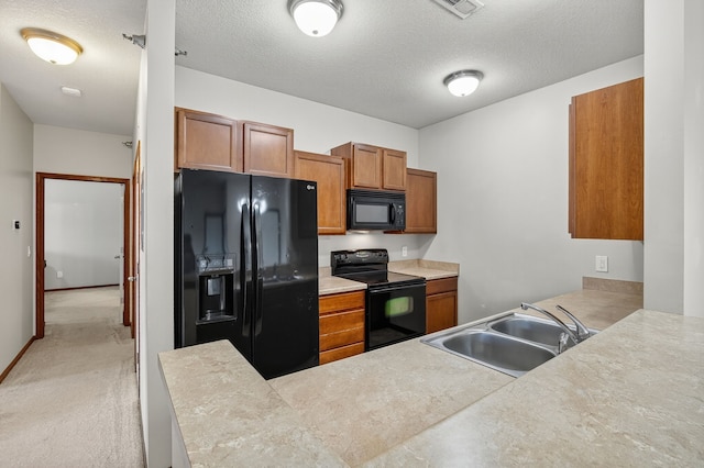 10320 Norfolk Dr Unit 7, Johnston, IA 50131 - kitchen featuring black appliances, brown cabinetry, a peninsula, light countertops, and a textured ceiling
