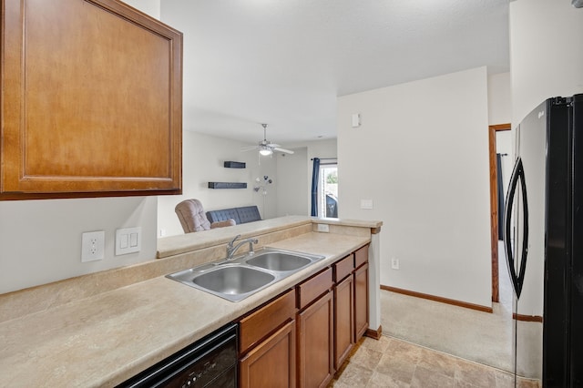 10320 Norfolk Dr Unit 7, Johnston, IA 50131 - kitchen with black appliances, brown cabinets, light countertops, ceiling fan, and light carpet