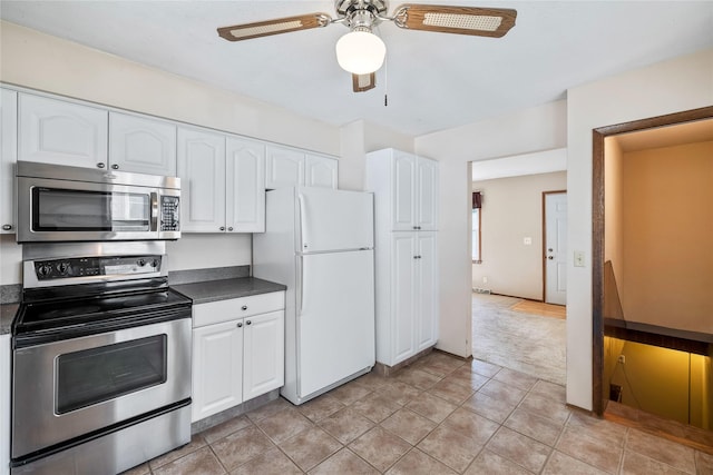 3520 E 32nd St, Des Moines, IA 50317 - kitchen with stainless steel appliances, dark countertops, and white cabinetry