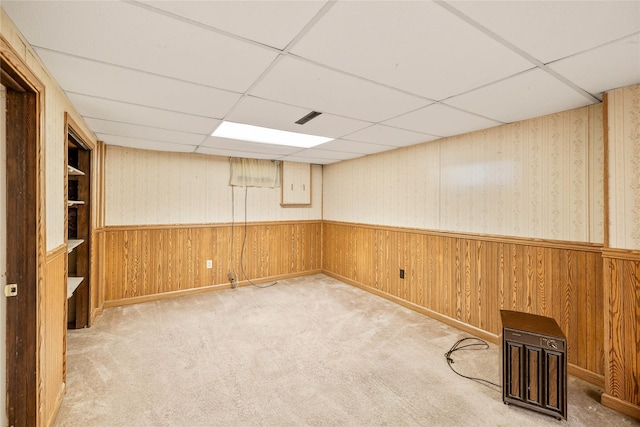 3520 E 32nd St, Des Moines, IA 50317 - finished below grade area featuring a drop ceiling, a wainscoted wall, carpet flooring, and wooden walls