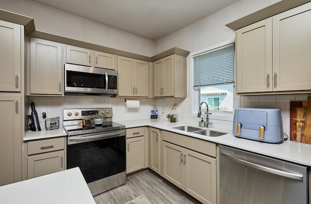 16621 Goodman Dr, Urbandale, IA 50323 - kitchen with stainless steel appliances, light countertops, light wood-type flooring, and backsplash