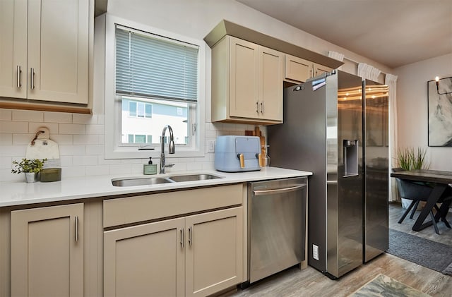 16621 Goodman Dr, Urbandale, IA 50323 - kitchen with appliances with stainless steel finishes, light wood-type flooring, light countertops, and backsplash