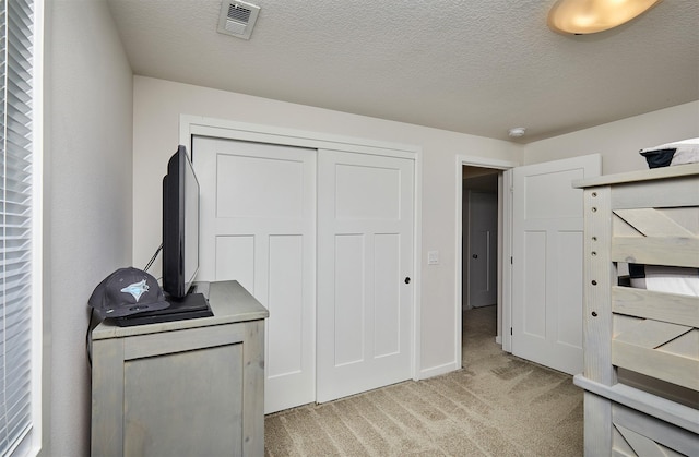 16621 Goodman Dr, Urbandale, IA 50323 - unfurnished bedroom with light colored carpet, a closet, and a textured ceiling