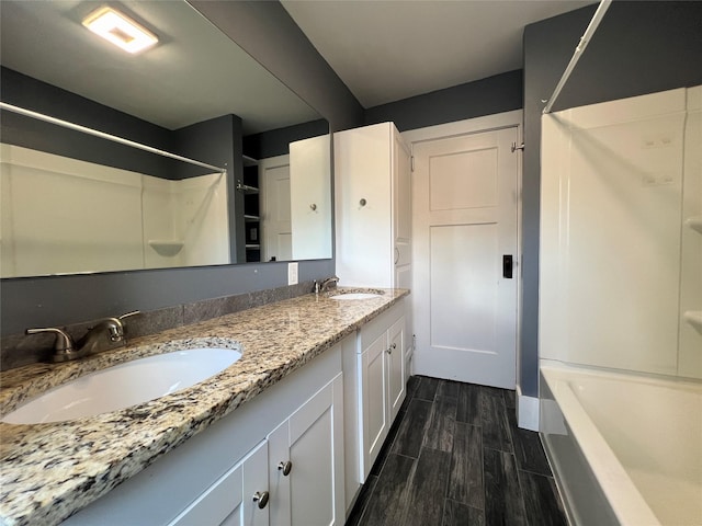 400 W Salem Ave, Indianola, IA 50125 - full bathroom featuring wood tiled floors, double vanity, and bathing tub / shower combination