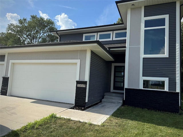 10009 Powell Ave, Johnston, IA 50131 - view of front of home with a garage, driveway, brick siding, and a front lawn