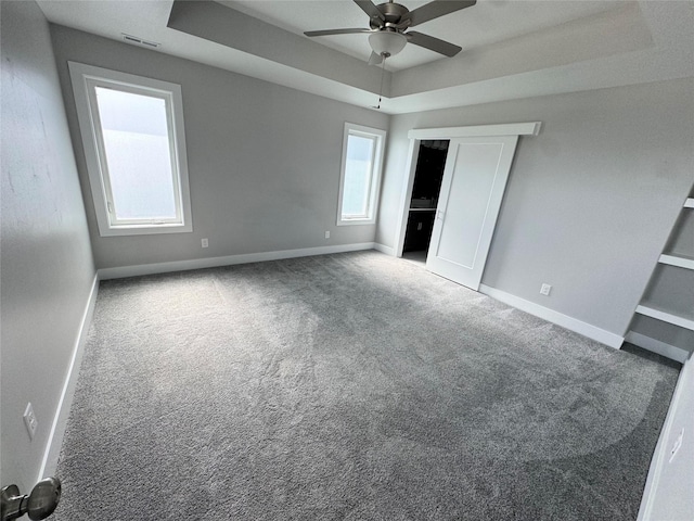 10009 Powell Ave, Johnston, IA 50131 - unfurnished bedroom with a raised ceiling, carpet floors, and ceiling fan