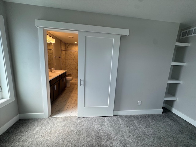 10009 Powell Ave, Johnston, IA 50131 - unfurnished bedroom featuring light marble finish flooring, light carpet, and connected bathroom