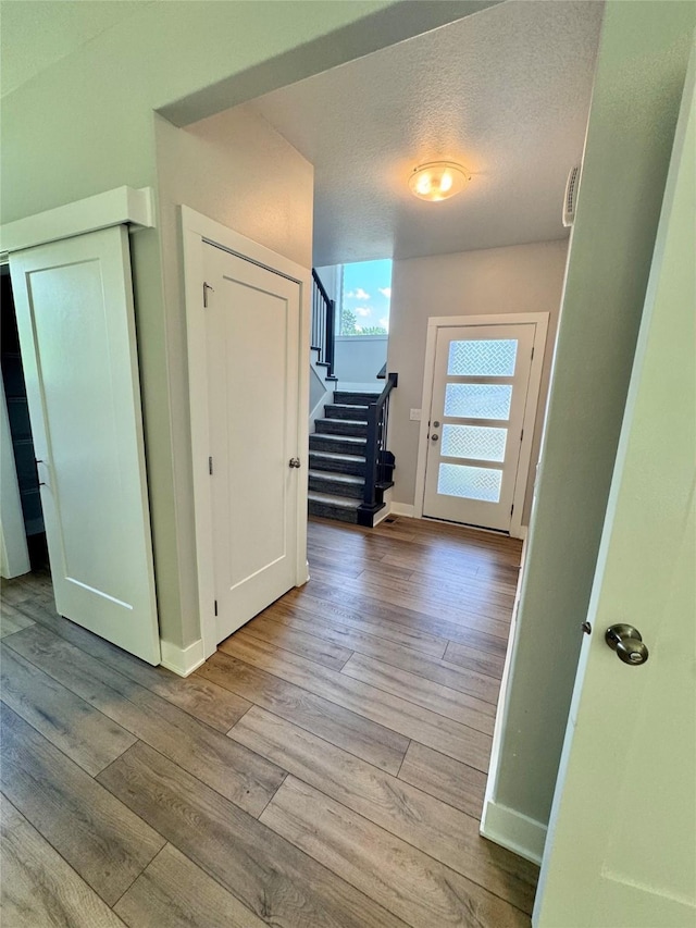 10009 Powell Ave, Johnston, IA 50131 - hall with stairway, wood finished floors, and a textured ceiling