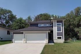 10009 Powell Ave, Johnston, IA 50131 - view of front of property with driveway, a front yard, and an attached garage