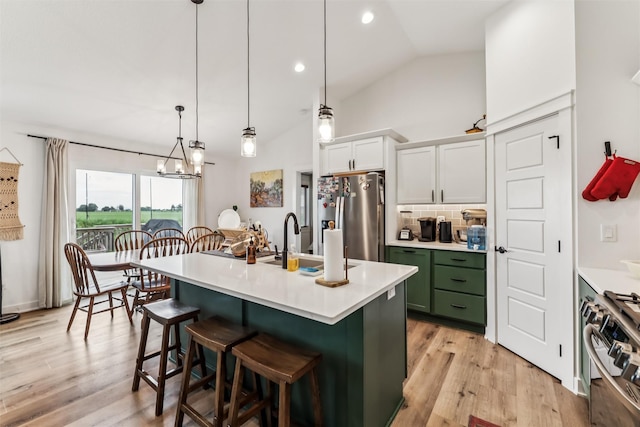 1819 8th Ave SE, Altoona, IA 50009 - kitchen with appliances with stainless steel finishes, green cabinets, backsplash, vaulted ceiling, and a breakfast bar area