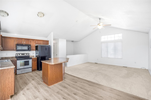 900 34th St SW, Bondurant, IA 50035 - kitchen featuring black appliances, ceiling fan, a kitchen island, vaulted ceiling, and light wood-style flooring