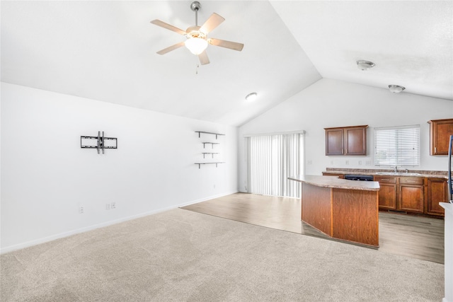 900 34th St SW, Bondurant, IA 50035 - kitchen with open floor plan, a kitchen island, lofted ceiling, light countertops, and ceiling fan