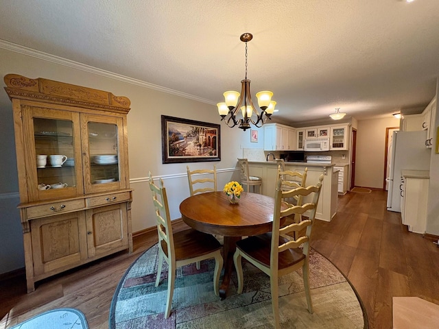 8844 Meredith Dr, Urbandale, IA 50322 - dining area featuring a chandelier, dark wood-type flooring, ornamental molding, and a textured ceiling
