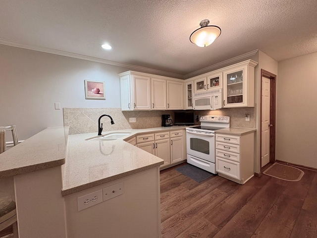 8844 Meredith Dr, Urbandale, IA 50322 - kitchen featuring white appliances, a peninsula, dark wood finished floors, glass insert cabinets, and crown molding