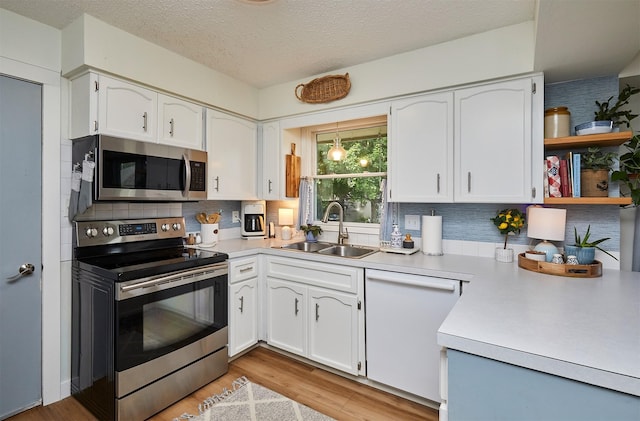 1506 S 14th St, Adel, IA 50003 - kitchen featuring appliances with stainless steel finishes, tasteful backsplash, white cabinets, light countertops, and a textured ceiling