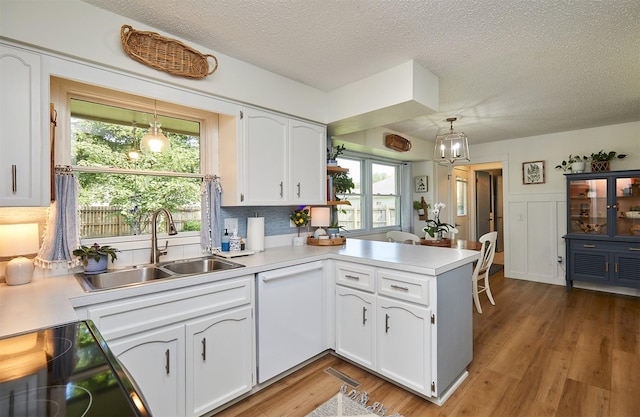 1506 S 14th St, Adel, IA 50003 - kitchen with dishwasher, a peninsula, a textured ceiling, white cabinetry, and light countertops