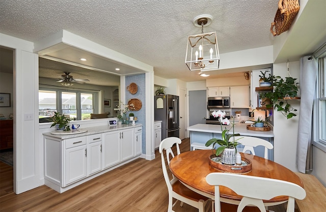 1506 S 14th St, Adel, IA 50003 - dining room with light wood-type flooring, a textured ceiling, a ceiling fan, recessed lighting, and a chandelier