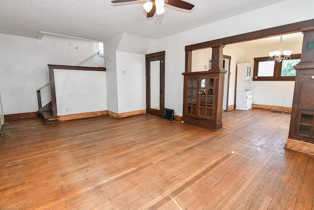 603 W Church St, Marshalltown, IA 50158 - unfurnished room with ceiling fan, hardwood / wood-style floors, a textured ceiling, stairway, and a chandelier