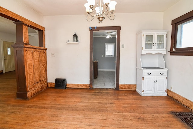 603 W Church St, Marshalltown, IA 50158 - unfurnished dining area with light wood finished floors, ceiling fan, a chandelier, and healthy amount of natural light