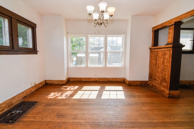 603 W Church St, Marshalltown, IA 50158 - unfurnished dining area featuring hardwood / wood-style flooring and a chandelier