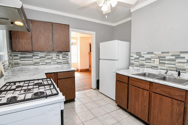 603 W Church St, Marshalltown, IA 50158 - kitchen with white appliances, extractor fan, a ceiling fan, backsplash, and light countertops