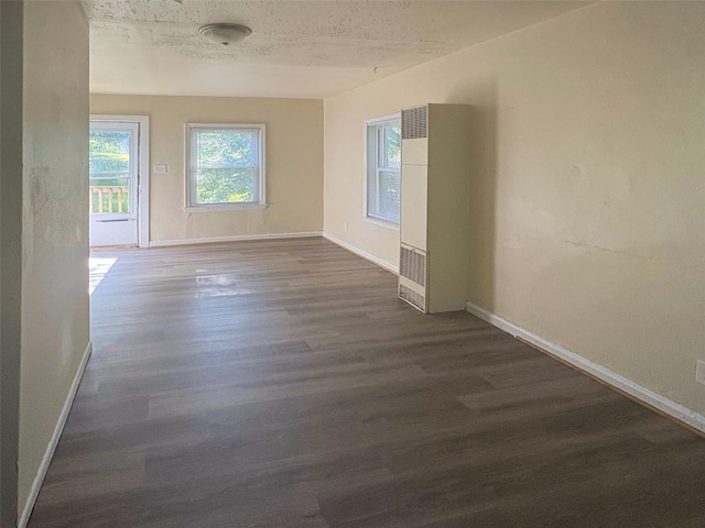 2826 Oxford St, Des Moines, IA 50313 - empty room with a heating unit and dark wood-style floors
