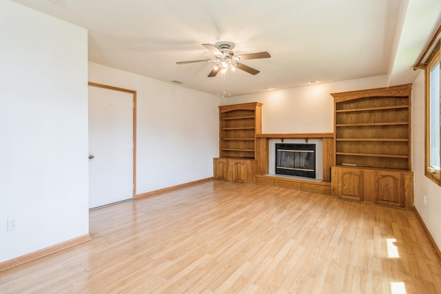 3612 SE 18th Ct, Des Moines, IA 50320 - unfurnished living room featuring light wood-style floors, a ceiling fan, and a glass covered fireplace