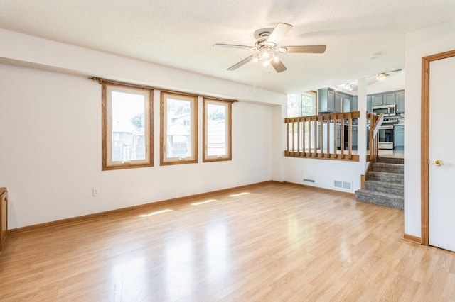 3612 SE 18th Ct, Des Moines, IA 50320 - empty room with a ceiling fan, light wood-type flooring, and stairs
