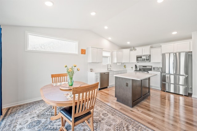 2708 NW Boulder Point Pl, Ankeny, IA 50023 - kitchen featuring stainless steel appliances, vaulted ceiling, white cabinets, light countertops, and light wood-style flooring
