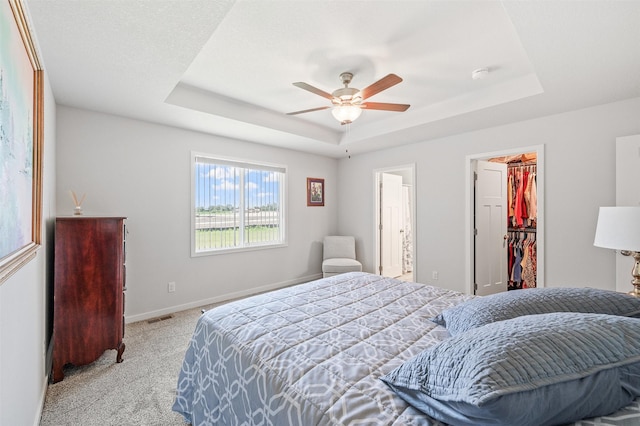 2708 NW Boulder Point Pl, Ankeny, IA 50023 - bedroom featuring a raised ceiling, light carpet, a spacious closet, ceiling fan, and a closet