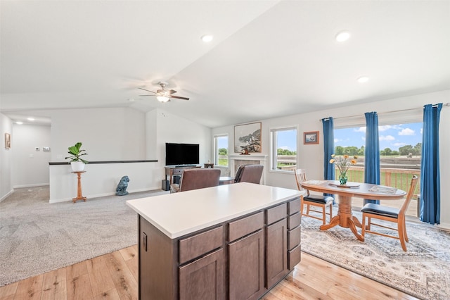 2708 NW Boulder Point Pl, Ankeny, IA 50023 - kitchen featuring a kitchen island, ceiling fan, light wood finished floors, vaulted ceiling, and light countertops